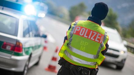 Ein Polizeibeamter beobachtet am 14.09.2015 an der Anschlussstelle Bad Reichenhall der Autobahn A8 von Salzburg nach München (Bayern) Fahrzeuge, die aus Österreich kommen.