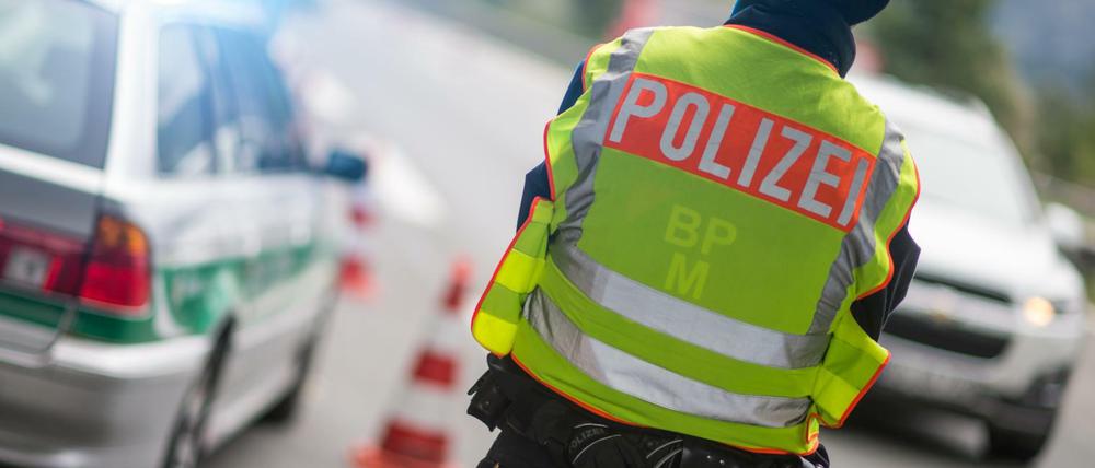 Ein Polizeibeamter beobachtet am 14.09.2015 an der Anschlussstelle Bad Reichenhall der Autobahn A8 von Salzburg nach München (Bayern) Fahrzeuge, die aus Österreich kommen.