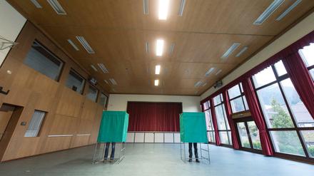 Zwei Wähler füllen am 13.03.2016 in Kirnbach (Baden-Württemberg) im Wahllokal in den Wahlkabinen ihre Stimmzettel für die baden-württembergische Landtagswahl aus.