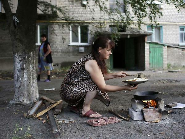 Akute Notlage. Eine Frau in der Region Lugansk muss wegen eines Ausfalls der Gasversorgung ihr Essen draußen zubereiten. 
