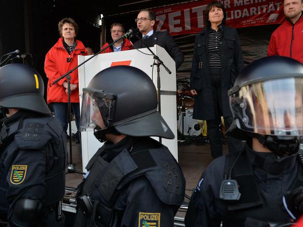 Polizei mit Helm und Schutzausrüstung sichert am 01.05.2016 während der Rede von Bundesjustizminister Heiko Maas (SPD, M) die Bühne auf der Maikundgebung in Zwickau (Sachsen). Die Kundgebung des DGB wurde massiv durch Pfiffe und Rufe von Islamgegnern gestört. 