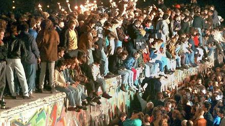 Stunde des Jubels. Feiernde Menschen auf der Berliner Mauer am 11. 11. 1989.