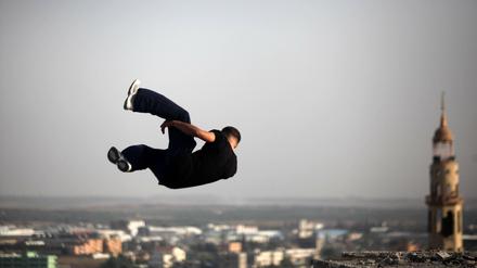 Gewagte Sprünge. Ein Jugendlicher trainiert seine akrobatischen Fähigkeiten inmitten zerstörter Gebäude in Beit Lahia im nördlichen Gazastreifen.  