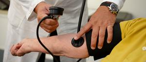 Ein Hausarzt misst den Blutdruck bei einer Patientin. Nach Ansicht von Sachverständigen sollten in Deutschland künftig auch "Teilkrankschreibungen" möglich sein. 