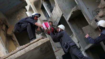 Nach einem Luftangriff: Mitglieder der syrischen Weißhelme bergen ein Mädchen aus einem zerbombten Gebäude.
