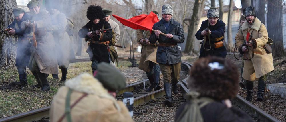 Nachgestellt. Diese Männer erinnern an den heroischen Kampf ukrainischer Studenten gegen die Rote Armee 1918 in Lemberg. In der Zentralukraine wurde derweil die Statue eines Kommunisten gestürzt. Symbole überlagern weiter die Politik.