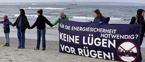 Mit einem Transparent und der Aufschrift „Für die Energiesicherheit notwendig? Keine Lügen vor Rügen“ stehen Menschen am Strand von Binz auf der Insel Rügen in einer Menschenkette als Protest gegen ein für die Insel vorgesehenes Flüssigerdgas-Terminal.  