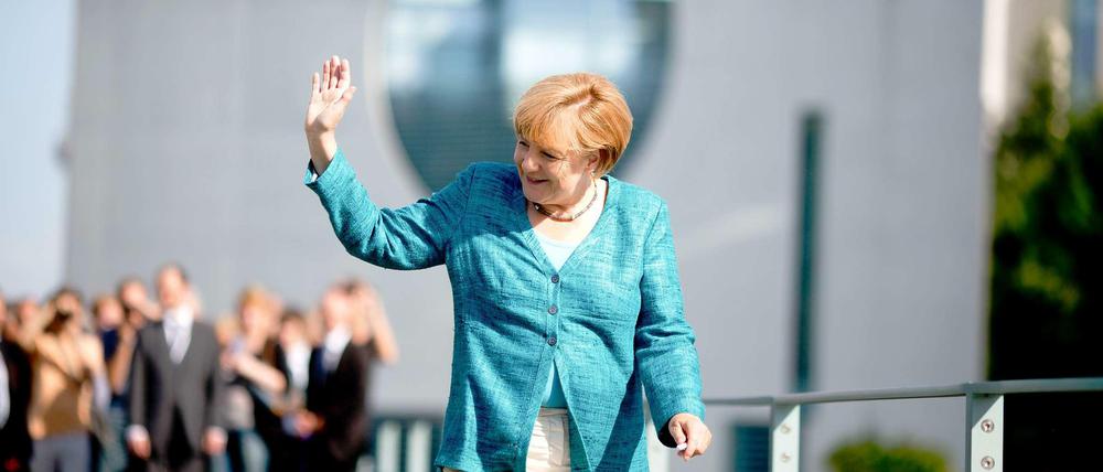 Merkel winkt der Menge zu.