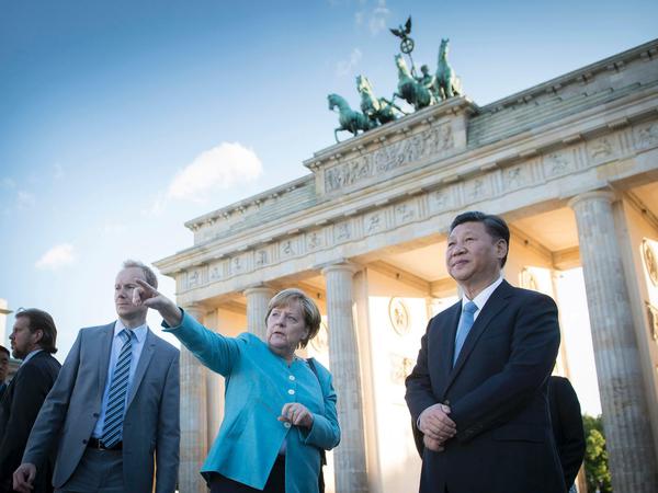 Der chinesische Präsident Xi Jinping (r) und Bundeskanzlerin Angela Merkel stehen vor dem Brandenburger Tor. in Berlin. 