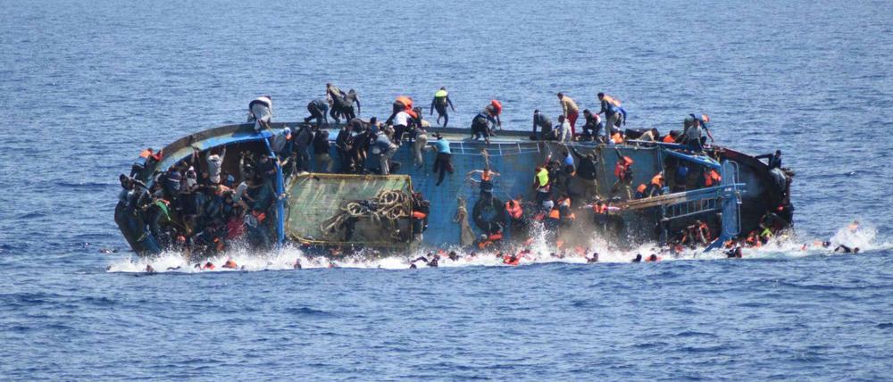 Ein kenterndes Flüchtlingsboot vor der Rettung durch die italienische Marine. 