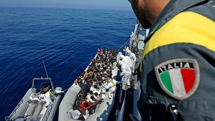 Ein italienisches Rettungsschiff nimmt auf dem Mittelmeer Flüchtlinge an Bord.