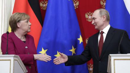 Angela Merkel und Russlands Präsident Wladimir Putin reichen sich die Hände. 