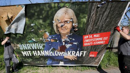 Ein stark beschädigtes Wahlplakat mit der abgewählten Ministerpräsidentin Kraft (SPD) wird in Mülheim abgebaut.