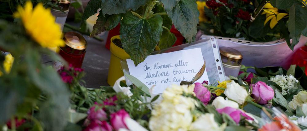 Vor dem Hamburger Supermarkt, in dem ein Kunde erstochen wurde, liegen Blumen, Kerzen und Worte der Trauer.