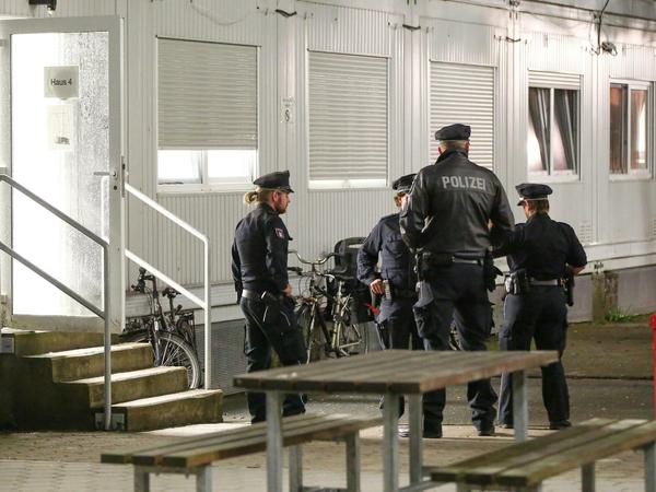 Einsatzkräfte der Polizei stehen am 28.07.2017 in Hamburg bei einer Durchsuchungsaktion vor Wohncontainern einer Flüchtlingsunterkunft.