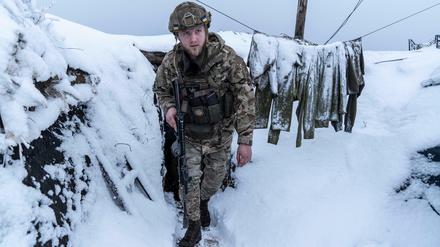 Ein ukrainischer Soldat im schneebedeckten Schützengraben an der Front in der von Russland besetzten Ostukraine. 