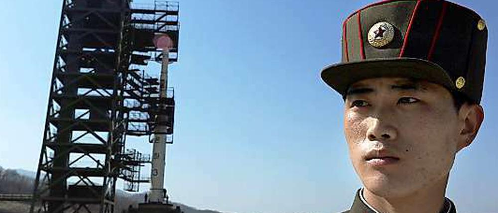 Ein Nordkoreanischer Soldat bewacht die Unha-3 Rakete in Tangachai. Ungeachtet der internationalen Kritik hat Nordkorea mit der Betankung der umstrittenen Rakete begonnen.