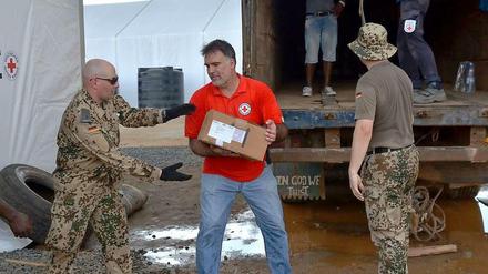 Soldaten der Bundeswehr und Helfer des Deutschen Roten Kreuzes richten in Monrovia ein Ebola-Behandlungszentrum ein.