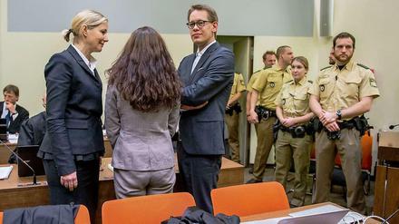 Die Angeklagte Beate Zschäpe (M) steht am 20.01.2015 im Gerichtssaal des Oberlandesgerichts in München (Bayern) zwischen ihren Anwälten Anja Sturm (l) und Wolfgang Heer (r) zu sehen.