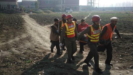 Pakistanische Rettungskräfte helfen einem Opfer der Angriffe auf eine Universität bei Peshawar.