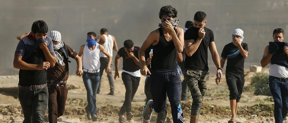 Palästinensische Jugendliche rennen östlich von Gaza-Stadt nach gewaltsamen Auseinandersetzungen mit dem israelischem Militär vor dem Tränengas davon.