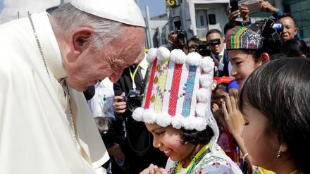 Papst Franziskus wird bei seiner Ankunft am Yangon International Airport in Myanmar von Kindern in traditioneller Kleidung begrüßt.