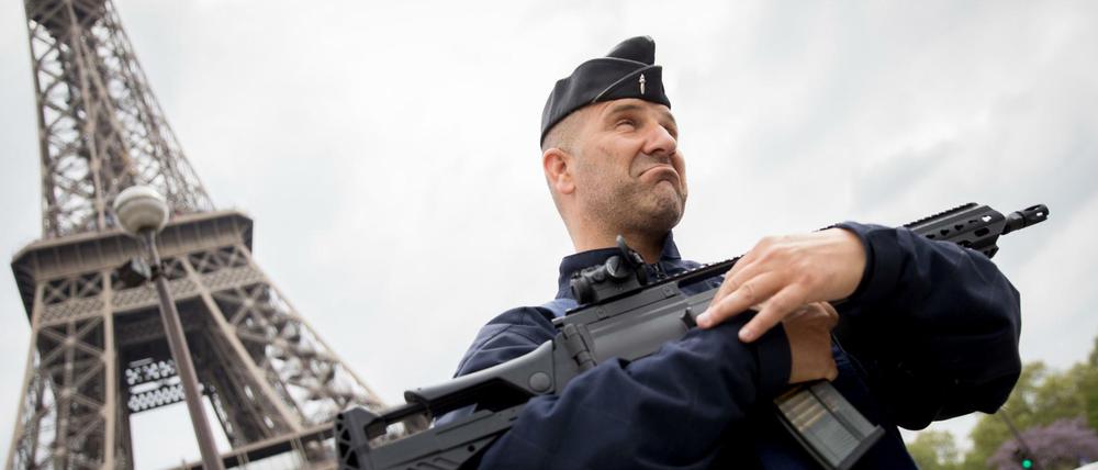 Ein schwer bewaffneter Polizist am Eiffelturm in Paris