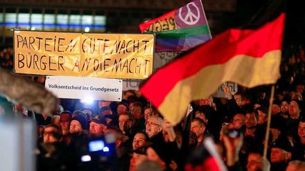 Diffuser Protest. "Pegida"-Demonstranten am Montag in Dresden. Im Hintergrund eine Friedensfahne.