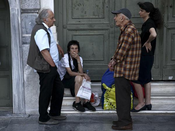 Rentner, die an ihr Geld wollen, stehen am Eingang einer Bank in Athen. ihre Bezüge R stehen in Athen vor dem Eingang einer BankPensioners wait outside a National Bank branch to receive part of their pension in Athens, Greece July 15, 2015. Greek banks will remain closed through to Thursday, the finance ministry said ahead of a parliamentary vote over tough austerity measures demanded by Greece's creditors in return for a third bailout. REUTERS/Yiannis Kourtoglou