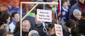 Pegida-Demonstranten zeigen Galgen für "Siegmar [sic] Gabriel" und "Angela "Mutti" Merkel.