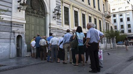 Vor einer Filiale der Nationalbank in Athen warten Menschen auf die Öffnung.