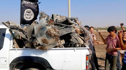 IS-Anhänger präsentieren angebliche Wrackteile eines syrischen Kampfjets.