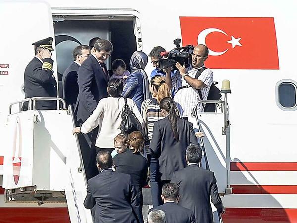 Der türkische Regierungschef Ahmet Davutoglu (links) besteigt auf dem Airport von Sanliurfa ein Flugzeug, in dem sich einige der befreiten Geiseln befinden. 