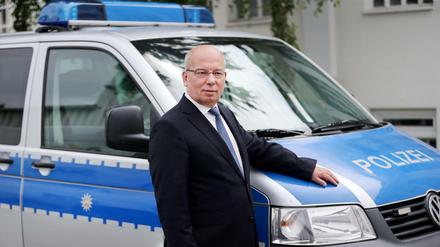 Der Bundesvorsitzende der deutschen Polizeigewerkschaft Rainer Wendt, der sich in der ARD-Vorabendserie "Rentnercops" selbst spielt, steht am 30. Juni 2016 in Köln (Nordrhein-Westfalen) in einer Drehpause an einem Polizeifahrzeug am Set.