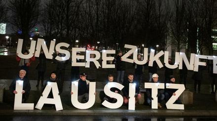 20 Menschen protestieren vor dem Kanzleramt in Berlin für Kohleverstromung. 