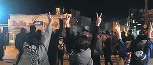 Protestierende Frauen ohne das vorgeschriebene Kopftuch heben ihre Hände und zeigen das Victory-Zeichen (Symbolbild).