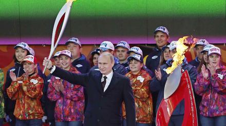 Russlands Präsident Wladimir Putin und das Olympische Feuer.