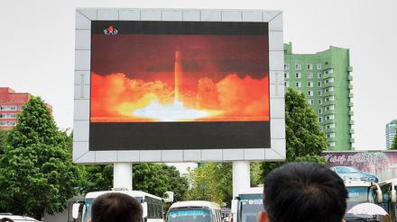 Menschen in Pjöngjang beobachten auf einer Leinwand den neueste nordkoreanische Raketentest.