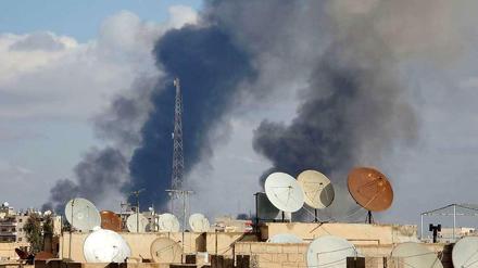 Über der syrischen Stadt Al-Rakka, einer Hochburg der IS-Extremisten, steigt Rauch auf. Sie soll von der syrischen Luftwaffe bombardiert worden sein.
