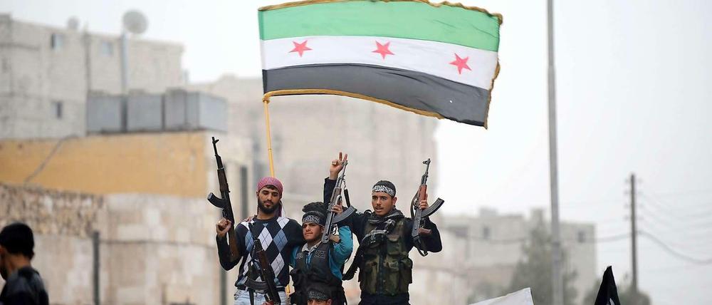 Syrische Rebellen in Aleppo strecken ihre Waffen in die Höhe. Seit zwei Jahren dauert der Bürgerkrieg bereits an.