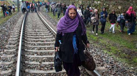 Flüchtlinge gehen an Eisenbahnschienen an der slowenischen Grenze entlang nach Österreich.