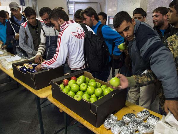 Flüchtlinge versorgen sich am Bahnhof Schönefeld mit Nahrungsmitteln. 