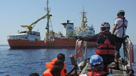 Von einem Schlauchboot gerettete Migranten werden auf ein Rettungsschiff von Ärzte ohne Grenzen und SOS Mediterranee gebracht.
