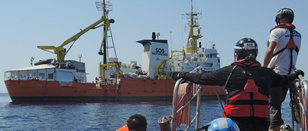 Von einem Schlauchboot gerettete Migranten werden auf ein Rettungsschiff von Ärzte ohne Grenzen und SOS Mediterranee gebracht.