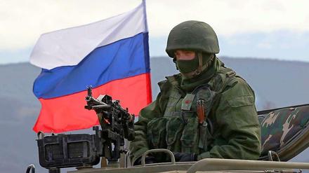 Offiziell nur ein bewaffneter Mann im Panzer vor der russischen Fahne auf der Krim. Inoffiziell: ein russischer Soldat.