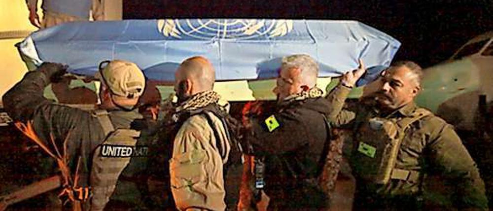 Mitglieder der Unama tragen den Sarg eines getöteten UN-Mitarbeiters.