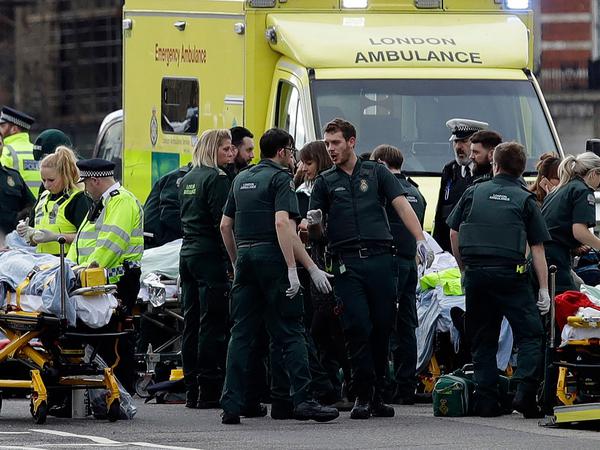 Verletzte werden in der Nähe des britischen Parlaments in London von Rettungskräften behandelt. In der Nähe des Londoner Parlaments sind am Mittwoch Schüsse gefallen.