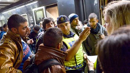Ein Polizist am Bahnhof von Stockholm im Gespräch mit Flüchtlingen.