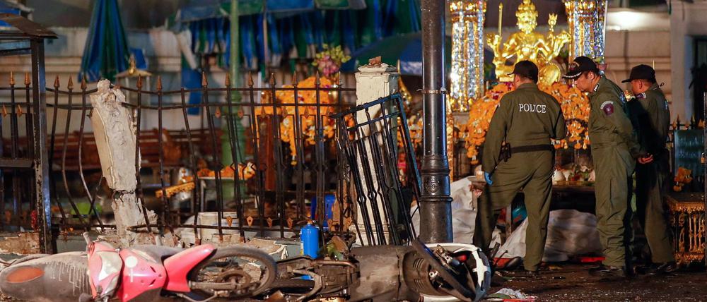 Nach der Bombenexplosion im Zentrum von Bangkok untersuchen Polizisten die Spuren. 