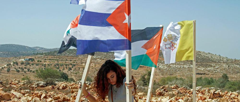 Demonstranten bringen in der Westbank die Fahnen von Ländern an, die sich politisch für die Rechte der Palästinenser einsetzen. 